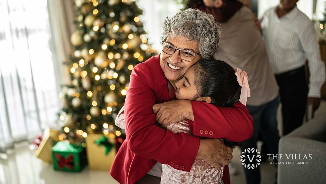 A grandmother hugs her granddaughter at Christmas.