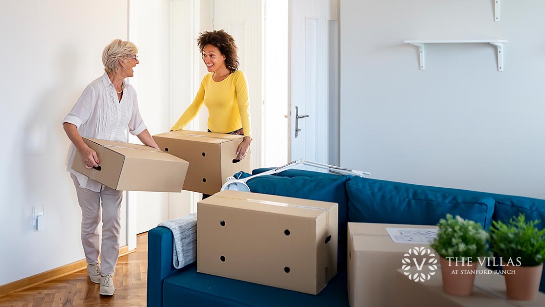 A senior woman moving into her new apartment, aided by her daughter.