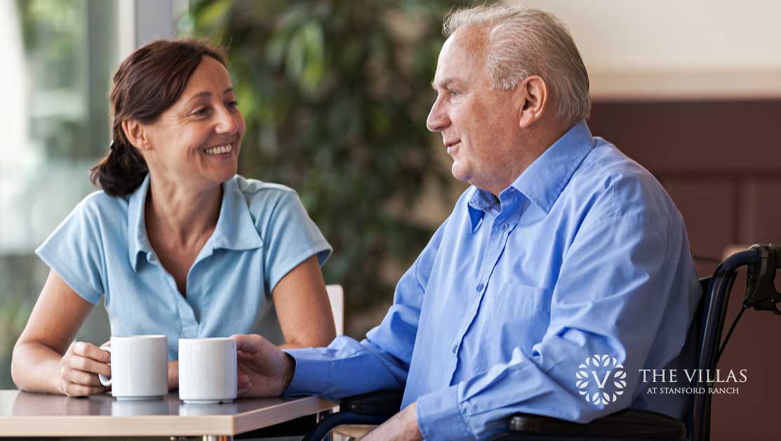 Female caregiver helping senior father. Learn more about caregivers and assisted living options at The Villas at Stanford Ranch.